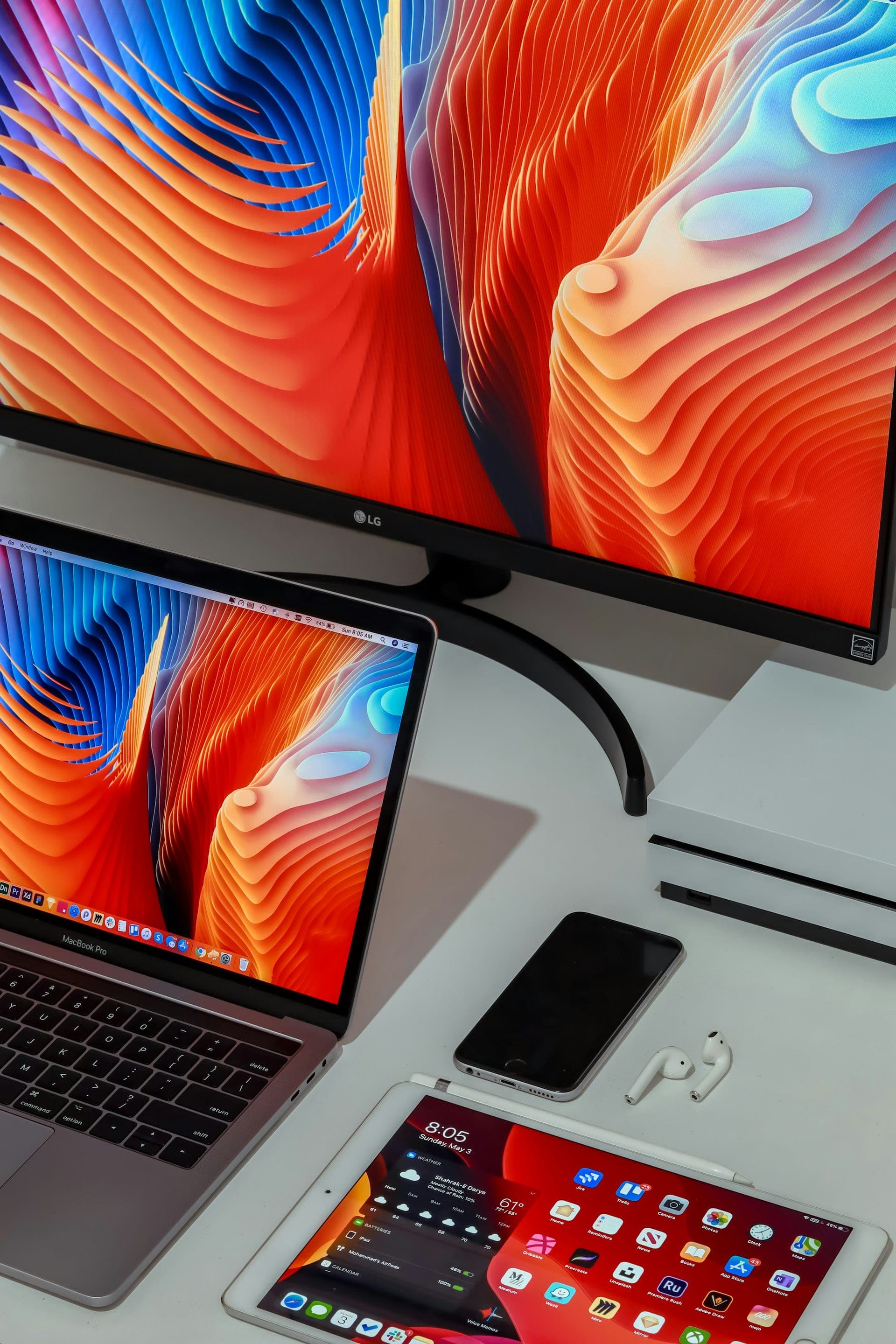 Flat-panel displays on a desk showing a warm gradient.